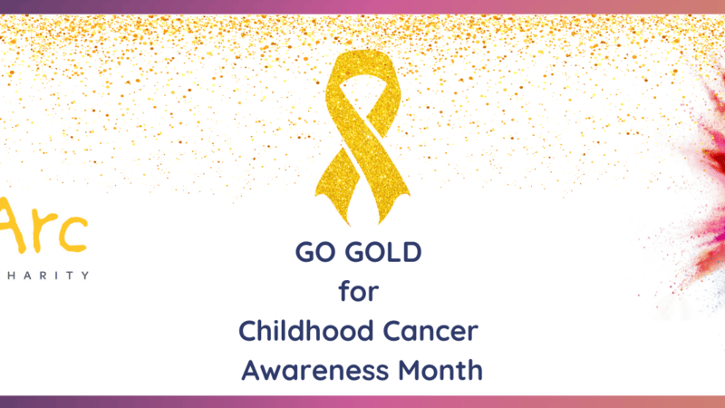 On the left side of the banner, there’s the “Alice’s Arc Children’s Cancer Charity” logo, featuring colourful handprints above the text. In the centre, a gold ribbon appears above the words “GO GOLD for Childhood Cancer Awareness Month.” On the right side, there’s the “Mexa Solutions” logo with a vibrant ink splash design. The background transitions from a sprinkle of gold dots on white to pink and blue hues toward the right edge.