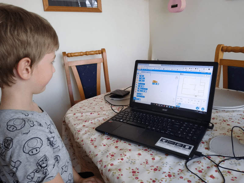 Boy looking at a computer screen with the Scratch programme he has designed.
