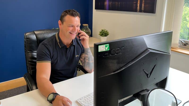 simon sat at his desk taking a call