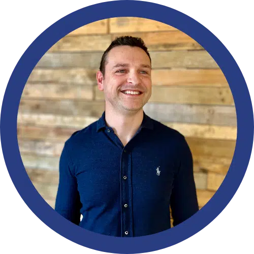 portrait of simon bath in a blue buttoned shirt