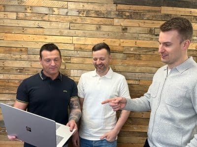3 young men looking at a laptop