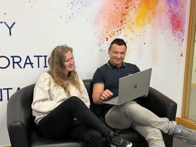 woman and man recruiter on a sofa looking through cvs on a laptop
