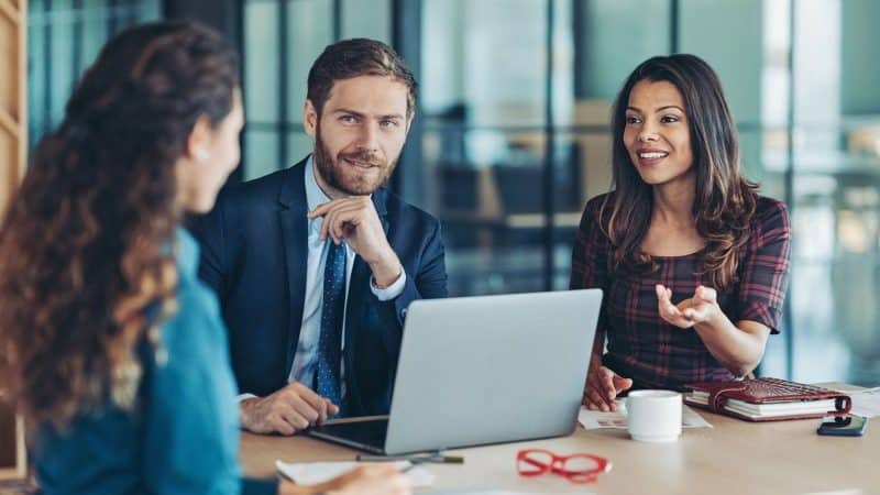 A man and woman chatting to another woman about offering her a new job