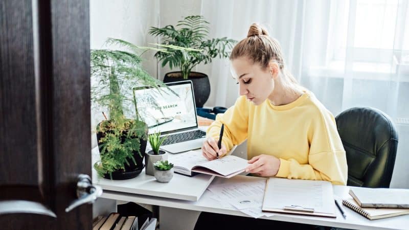 lady in yellow at her desk working looking for a new job 
