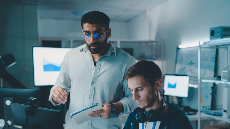 two office workers looking at a computer screen working on cybersecurity