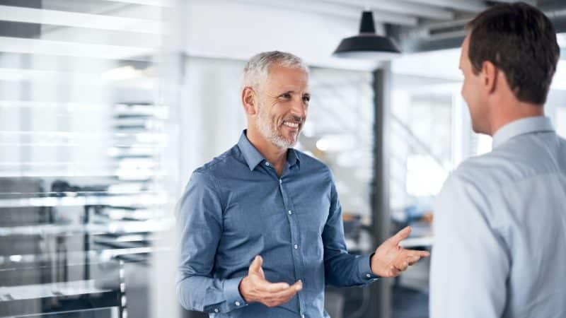 man talking to man in an office